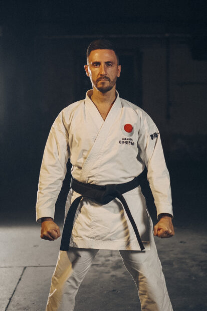 A serious karate martial artist stands wearing a white uniform and black belt, HD Mobile Wallpaper