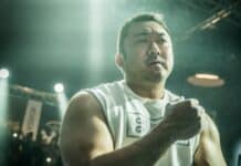 Ma Dong Seok focuses intensely during a fight scene under bright lights, HD Desktop Wallpaper