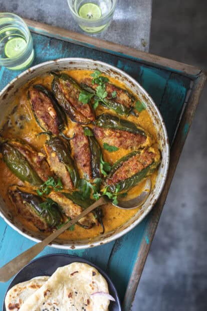 A skillet filled with stuffed jalapenos cooked in a creamy sauce garnished with herbs, 2K Mobile Wallpaper