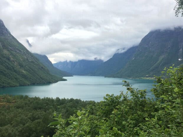 The Norwegian fjords show lush greenery and calm water under a cloudy sky, HD Desktop Wallpaper