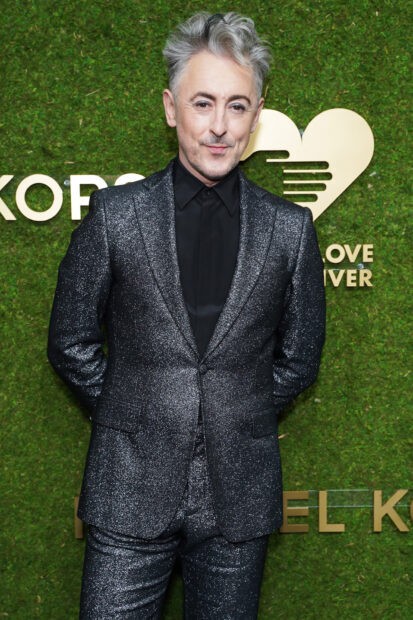 Alan Cumming wears a sparkling suit while posing at an event with a green background, HD Desktop Wallpaper