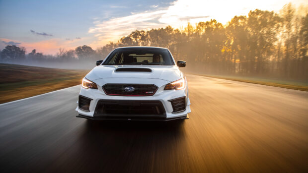 A white Subaru WRX is driving on the road during sunset with a blurred background, 4K Desktop Wallpaper