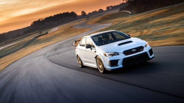 A white Subaru WRX is driving fast on a winding race track during sunset, HD Desktop Wallpaper