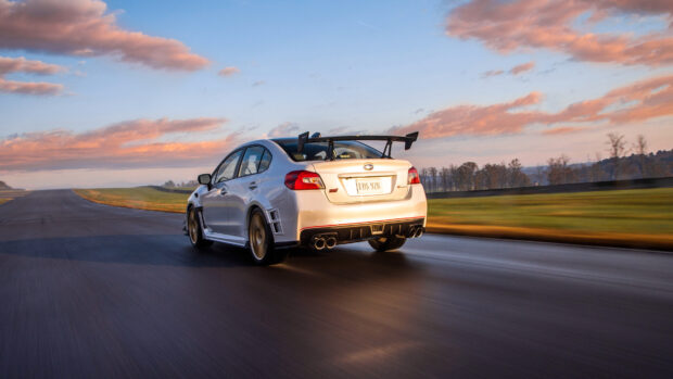 A white Subaru WRX is driving fast on a racetrack during sunset with blurred background, 4K Desktop Wallpaper