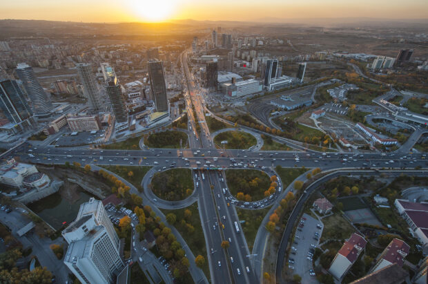 The Ankara Wallpapers display a sunset casting golden light over the city skyline and highways, HD Desktop Wallpaper