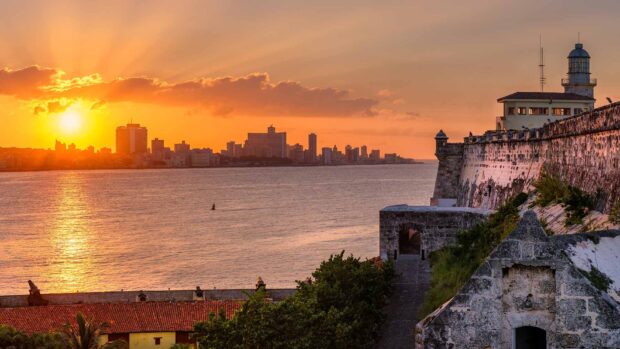 The Havana Cuba skyline glows under a vibrant sunset sky by the water, HD Desktop Wallpaper