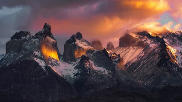 The golden light illuminates the rocky mountains in Torres Del Paine National Park, 4K Desktop Wallpaper
