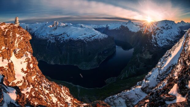 The Norwegian fjords show a sunset with snow covered mountains and calm water in the valley, HD Desktop Wallpaper