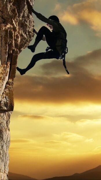 A climber gripping the rock face during a sunset in rock climbing wallpapers, HD Mobile Wallpaper
