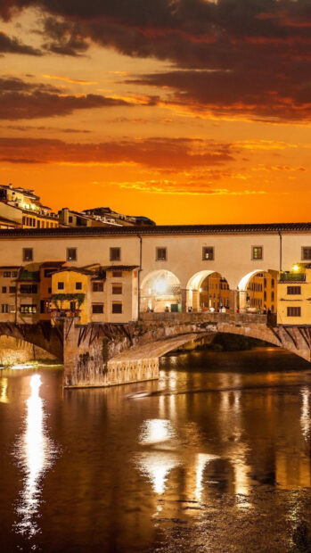 The Ponte Vecchio bridge glows warmly against the sunset sky over the Arno river, HD Mobile Wallpaper