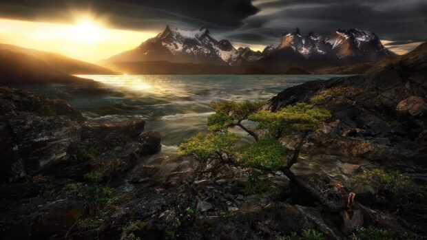 The sun sets behind the majestic Torres Del Paine National Park with rocky foreground, HD Desktop Wallpaper
