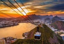 A cable car is floating above Rio De Janeiro at sunset with city and mountains in the background, HD Desktop Wallpaper