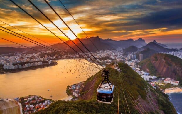 A cable car is floating above Rio De Janeiro at sunset with city and mountains in the background, HD Desktop Wallpaper