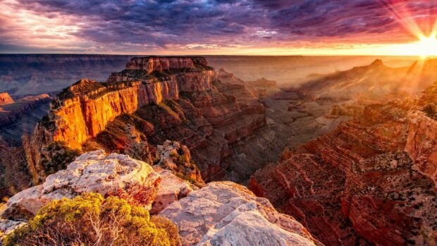 The sunset casts warm light over the Grand Canyon cliffs and rock formations