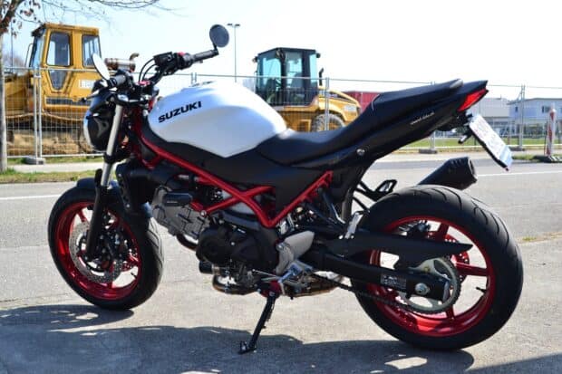 A white Suzuki Sv650 motorcycle is parked near a construction site on a sunny day, HD Desktop Wallpaper