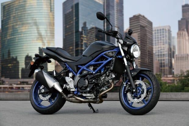 A Suzuki Sv650 motorcycle parked with city buildings in the background, HD Desktop Wallpaper