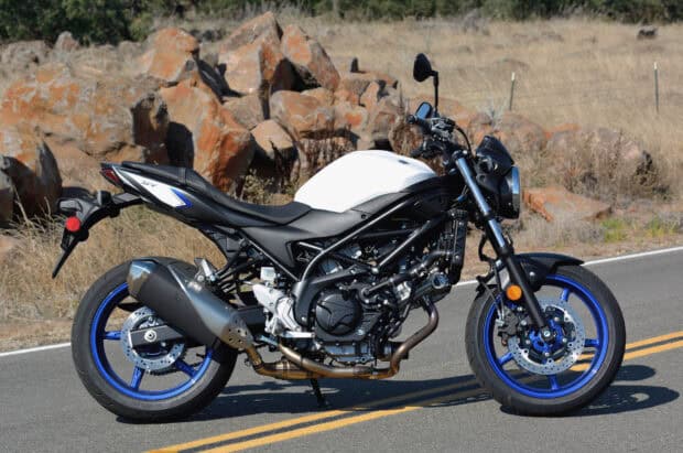 A Suzuki Sv650 motorcycle is parked on a road near rocks, HD Desktop Wallpaper