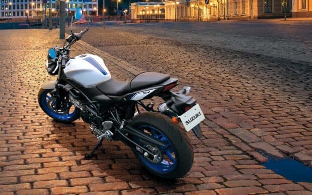 A white Suzuki Sv650 parked on a cobblestone street during sunset, HD Desktop Wallpaper