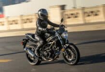 A rider is wearing black gear while riding a Suzuki Sv650 motorcycle on the road, HD Desktop Wallpaper