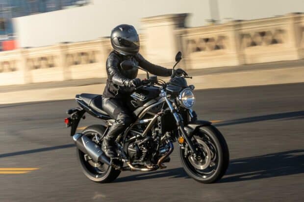 A rider is wearing black gear while riding a Suzuki Sv650 motorcycle on the road, HD Desktop Wallpaper