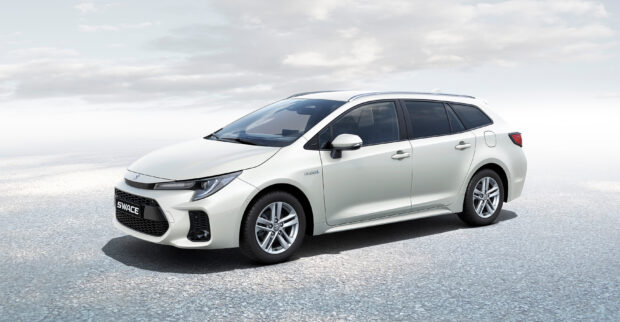 A white Suzuki Swace hybrid station wagon is parked on a gray textured surface under a cloudy sky, 2K Desktop Wallpaper