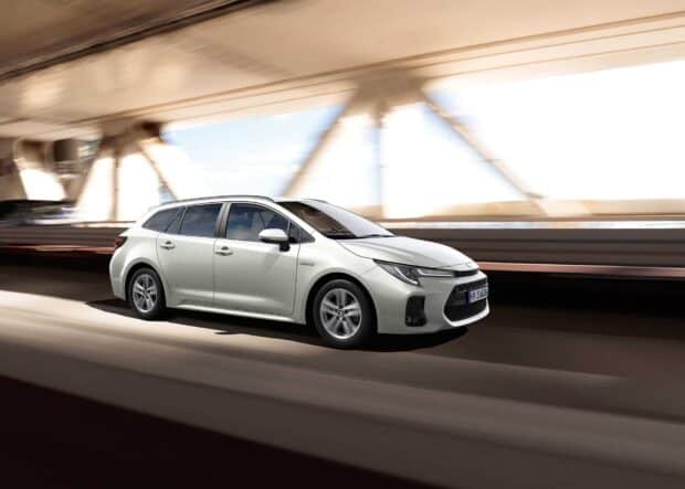 A white Suzuki Swace drives forward on a bridge with structural beams visible behind it, HD Desktop Wallpaper