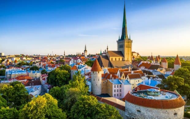 A scenic view of Estonia showcases historic churches and towers at sunset, HD Desktop Wallpaper