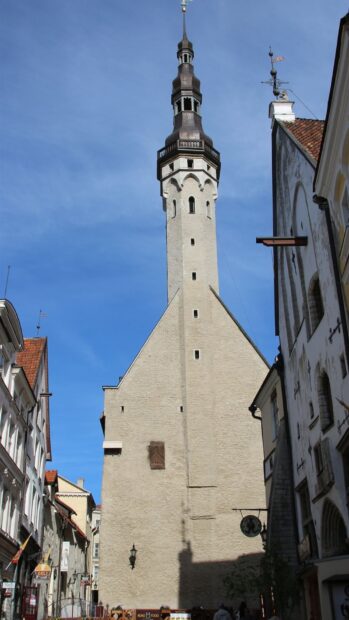 A tall historic tower surrounded by buildings in Estonia under a clear blue sky, HD Mobile Wallpaper