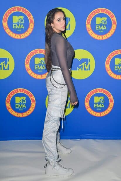 Tate Mcrae stands confidently in front of a colorful MTV EMA 2020 backdrop, 2K Desktop Wallpaper