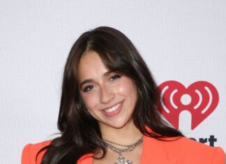 Tate Mcrae wears an orange blazer and black lace top while smiling at an event, HD Desktop Wallpaper