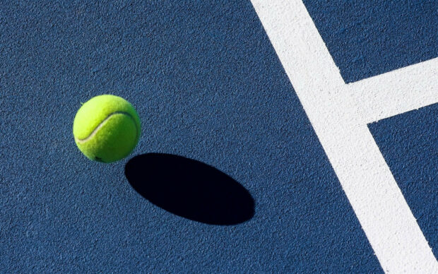 A tennis ball is hovering over the blue court surface near the white line, featuring tennis wallpapers, HD Desktop Wallpaper