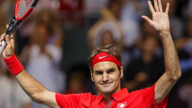 A tennis player in a red outfit raises his hands in celebration during a match, 4K Desktop Wallpaper