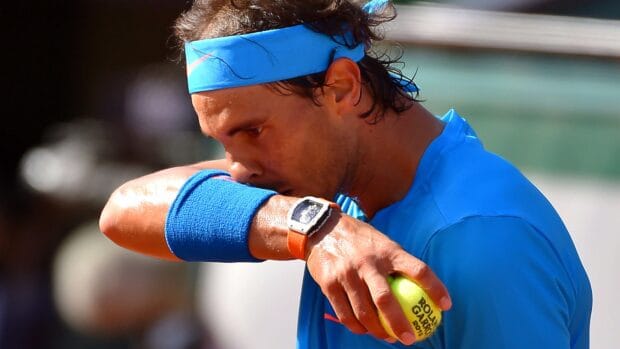 A tennis player holds a ball and wipes sweat during the French Open Roland Garros match, 4K Desktop Wallpaper