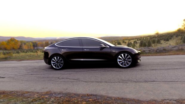 A black Tesla Model 3 is parked on a country road during sunset displaying sleek design, HD Desktop Wallpaper