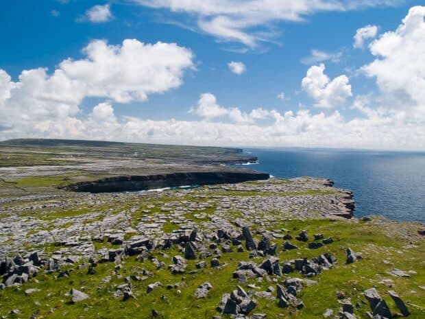 The Aran Islands feature rocky cliffs under a blue sky with clouds, HD Desktop Wallpaper