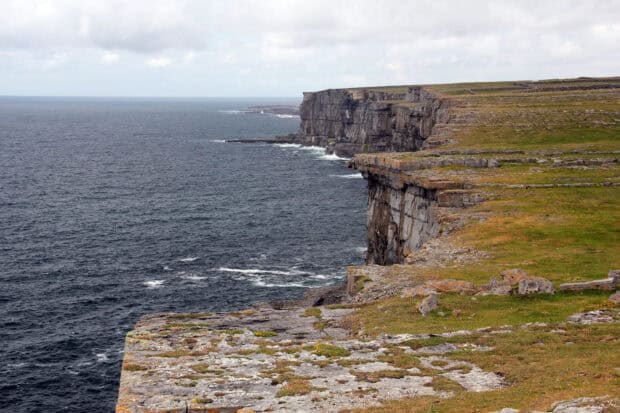 The Aran Islands feature dramatic cliffs along the coastline under a cloudy sky, HD Desktop Wallpaper