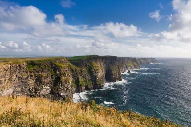 The Aran Islands feature rugged cliffs meeting the ocean under a cloudy sky, HD Desktop Wallpaper