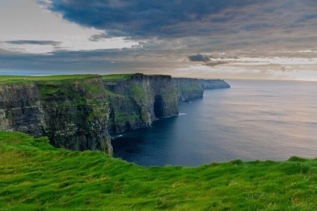 The Aran Islands show dramatic cliffs and green grass under a cloudy sky, HD Desktop Wallpaper