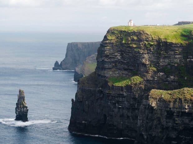 The Aran Islands showcase stunning cliffs meeting the ocean under a cloudy sky, HD Desktop Wallpaper