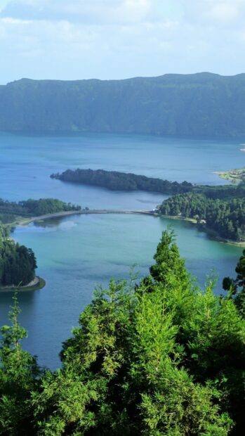 The Azores Wallpapers show a serene volcanic lake surrounded by lush greenery and mountains, HD Phone Wallpaper