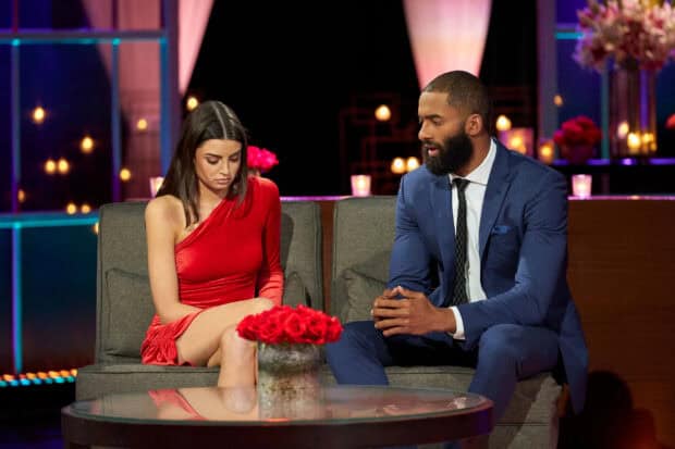 A woman in a red dress and a man in a blue suit have a serious conversation on The Bachelor Tv Series, 2K Desktop Wallpaper