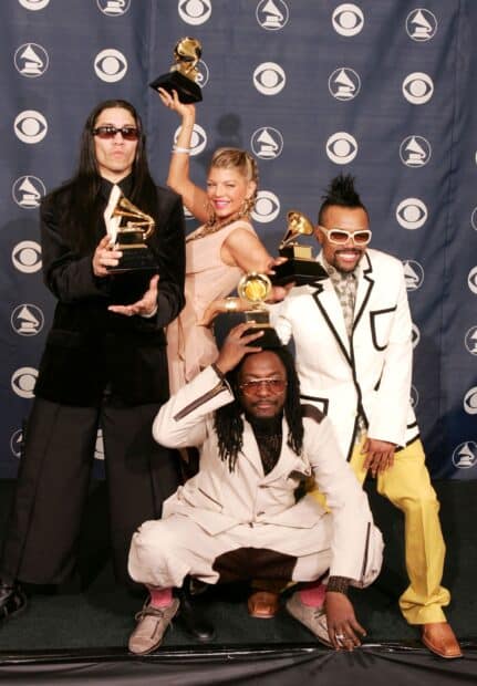 The Black Eyed Peas holding Grammy trophies at an event celebrating their music success, 2K Desktop Wallpaper