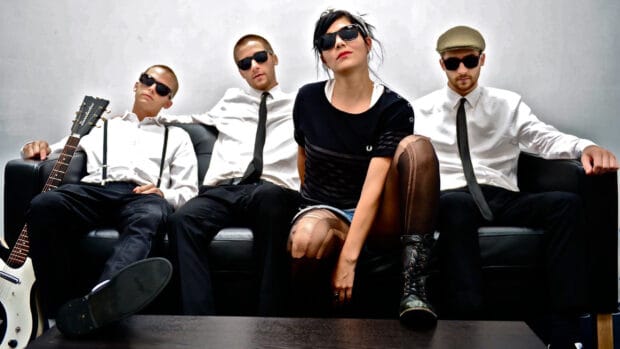 The Interrupters band members wearing sunglasses and posing on a couch, HD Desktop Wallpaper
