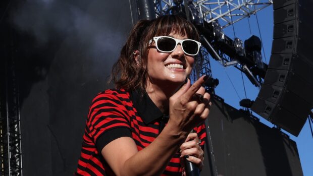 The Interrupters lead singer smiling and engaging with the crowd during a concert, HD Desktop Wallpaper