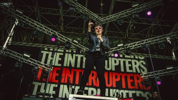 The Interrupters perform energetically on stage with lights and microphone, HD Desktop Wallpaper
