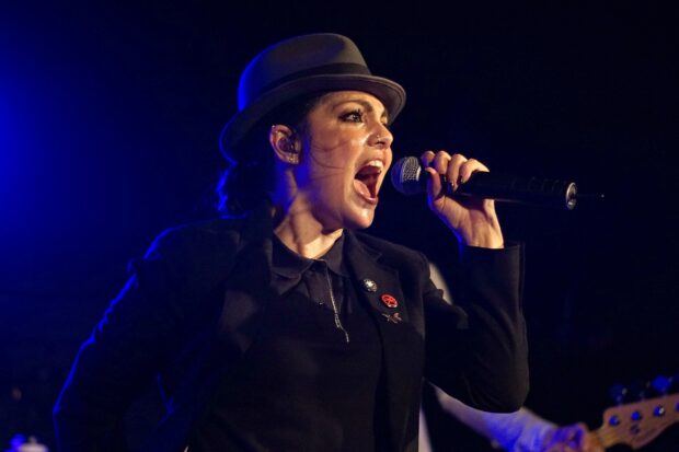 A singer from The Interrupters passionately performing on stage, 2K Desktop Wallpaper