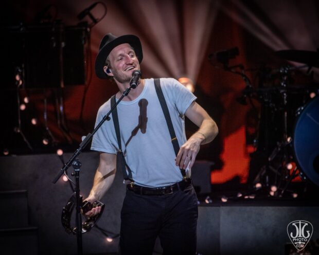 The Lumineers lead singer smiles while performing on stage during a concert, HD Desktop Wallpaper