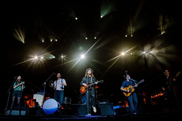 The Lumineers perform on stage with instruments under bright stage lights, 2K Desktop Wallpaper