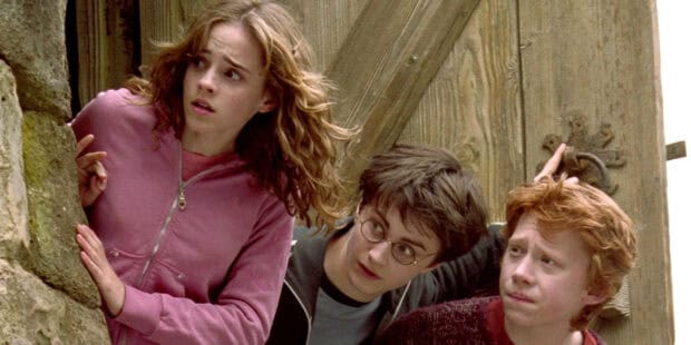 The Prisoner Of Azkaban characters cautiously peek from behind a wooden door in a tense moment, 2K Desktop Wallpaper