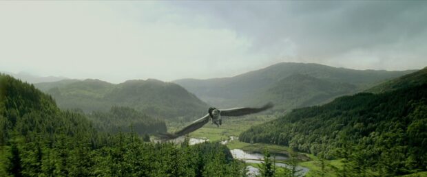 A magical creature flying over a lush green valley under a cloudy sky in The Prisoner Of Azkaban, 4K Desktop Wallpaper